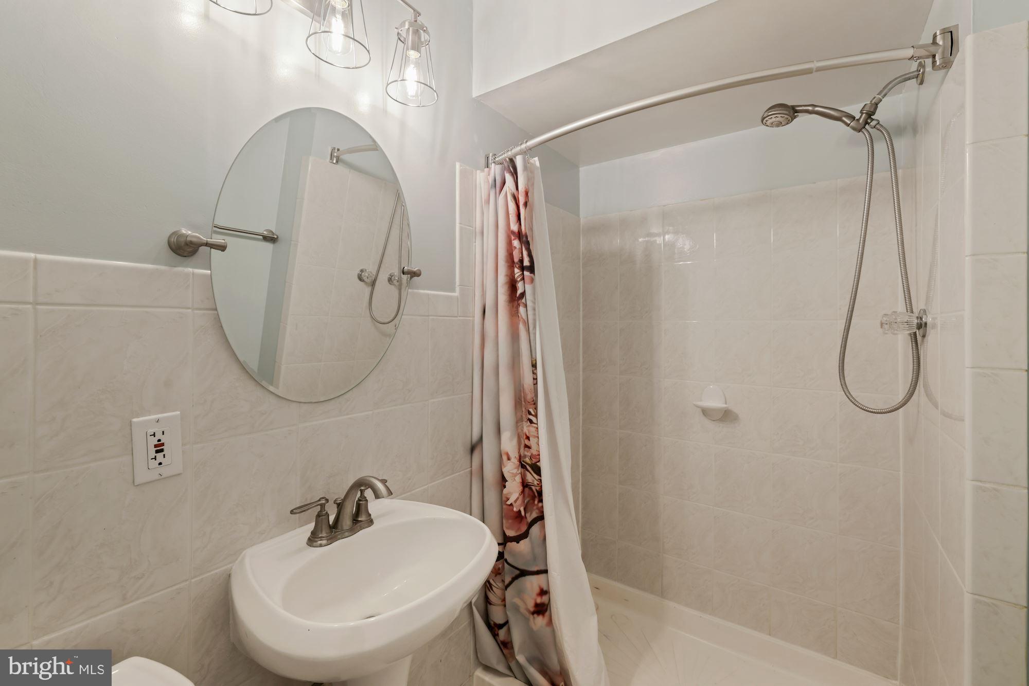 7716 Beech Tree Road Bethesda, MD 20817 - Photo 47 of 49 a bathroom with a sink a toilet and shower