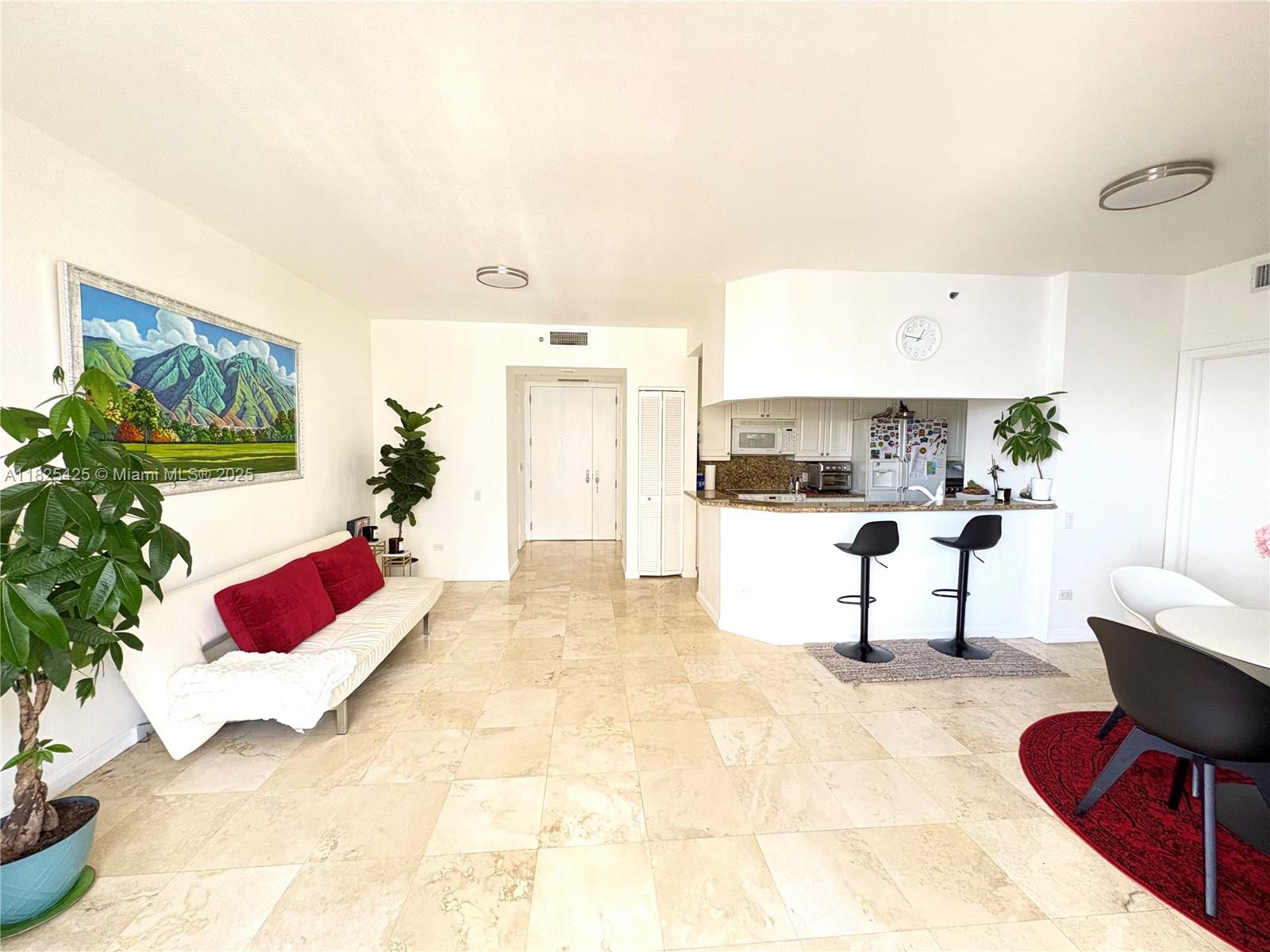808 Brickell Key Drive, Unit 1103 Miami, FL 33131 - Photo 2 of 12 a living room with furniture and flowers