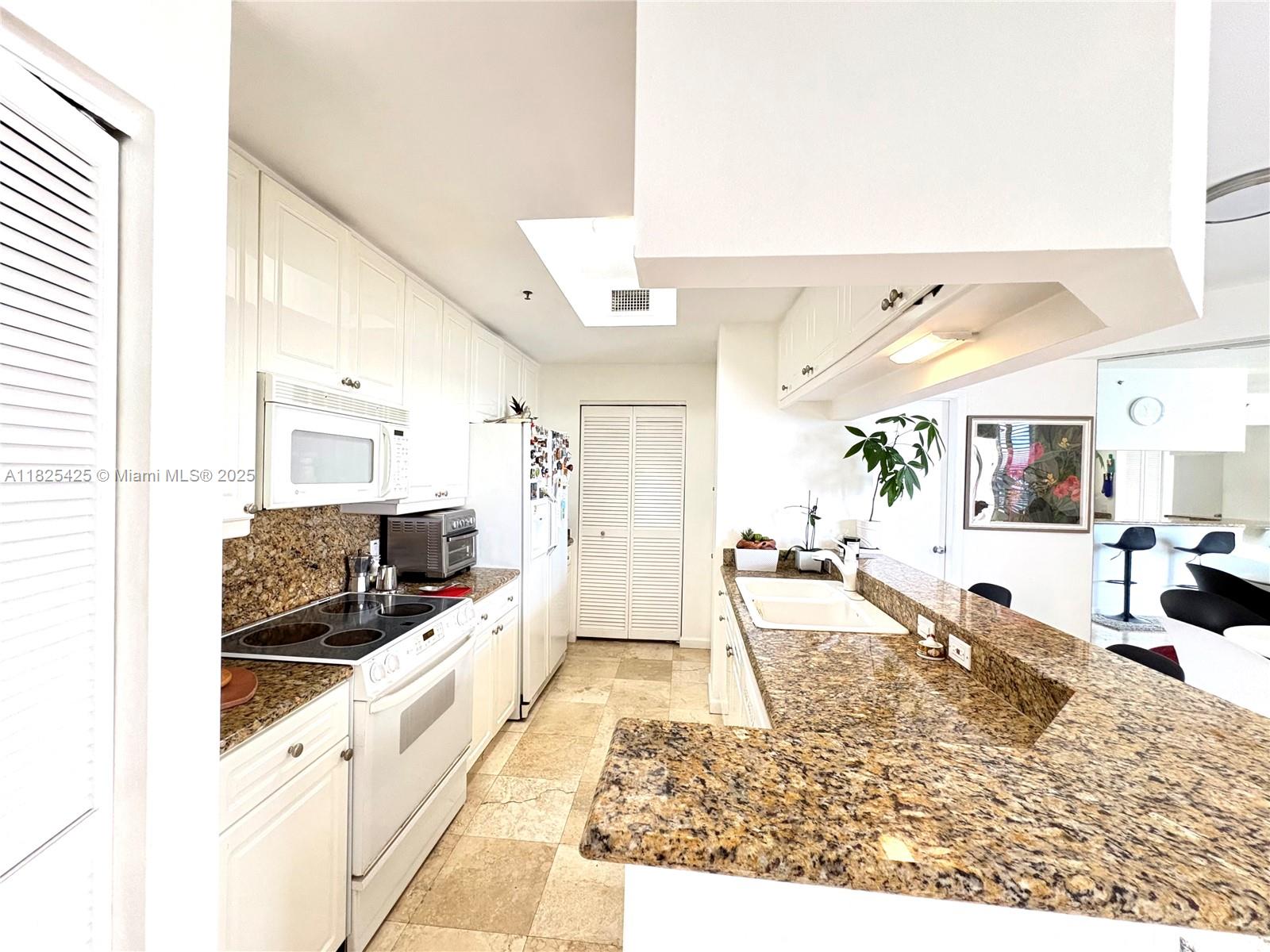808 Brickell Key Drive, Unit 1103 Miami, FL 33131 - Photo 4 of 12 a living room with stainless steel appliances kitchen island granite countertop furniture and a view of living room