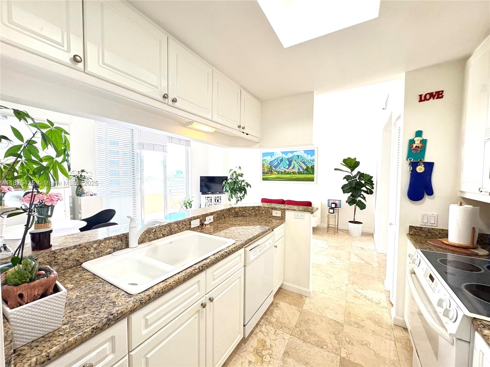 808 Brickell Key Drive, Unit 1103 Miami, FL 33131 - Photo 5 of 12 a kitchen with stainless steel appliances granite countertop a sink and a stove