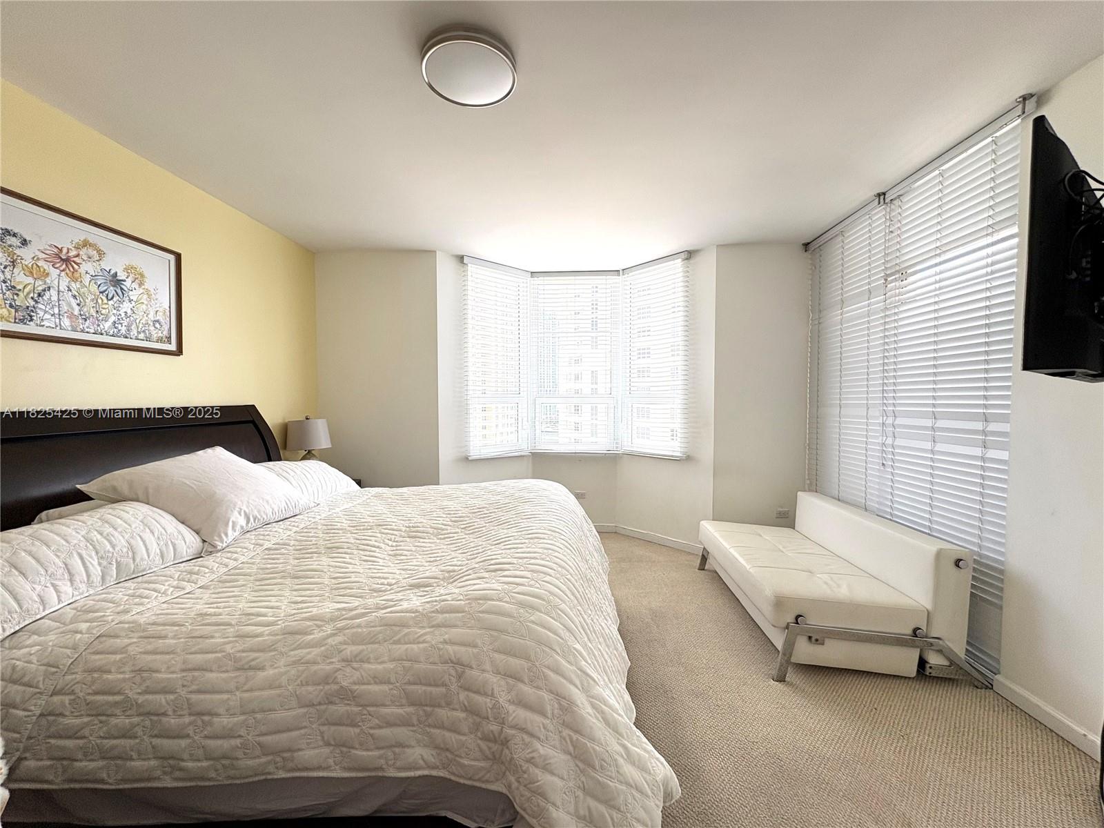 808 Brickell Key Drive, Unit 1103 Miami, FL 33131 - Photo 7 of 12 a bedroom with a bed and a window