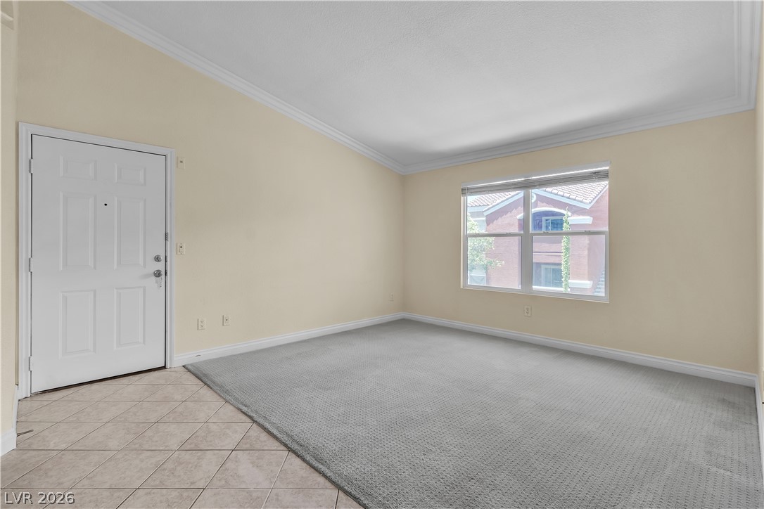8101 West Flamingo Road, Unit 2001 Las Vegas, NV 89147 - Photo 5 of 28 The entryway seamlessly transitions into a carpeted living space with crown molding and an inviting window.