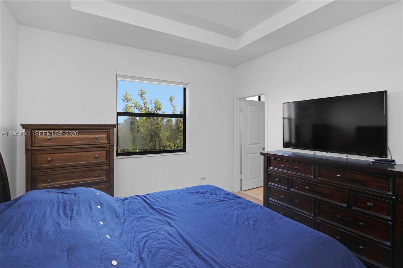 10125 Southwest 228th Terrace Miami, FL 33190 - Photo 21 of 26 a bedroom with a bed and flat screen tv