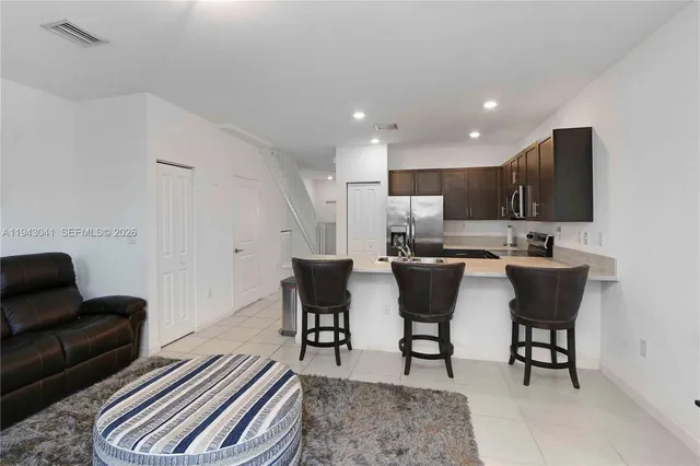 a living room with furniture and a dining table with wooden floor