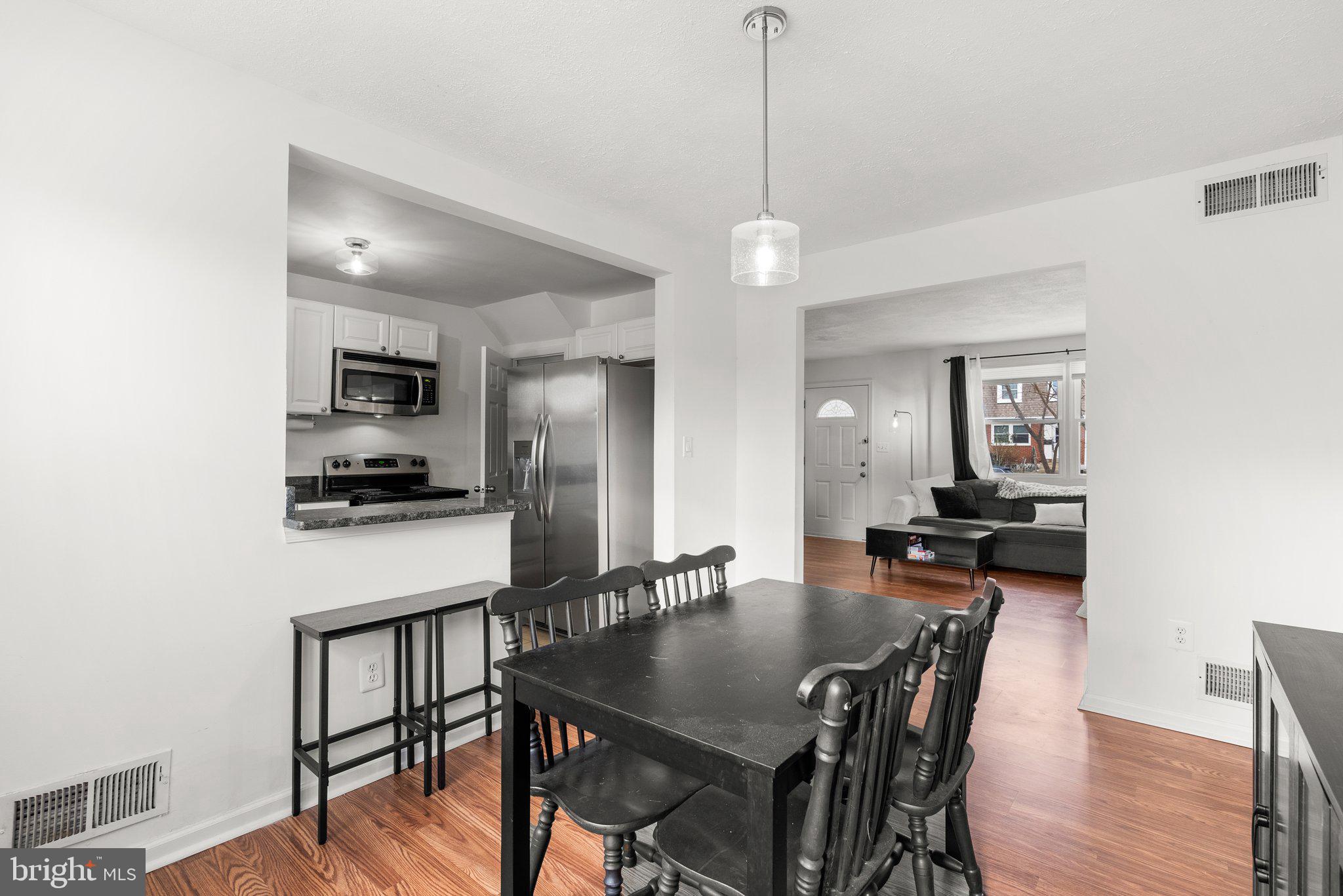 40 Bladen Road Baltimore, MD 21221 - Photo 11 of 44 a kitchen with stainless steel appliances granite countertop a dining table chairs refrigerator and microwave