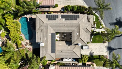 an aerial view of residential houses with outdoor space and parking