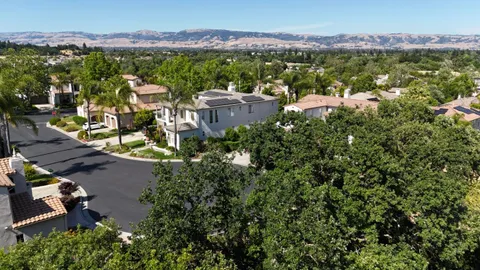 an aerial view of residential houses with outdoor space and mountain view