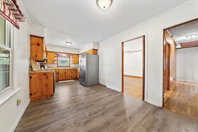 a view of a kitchen with wooden floor electronic appliances and windows