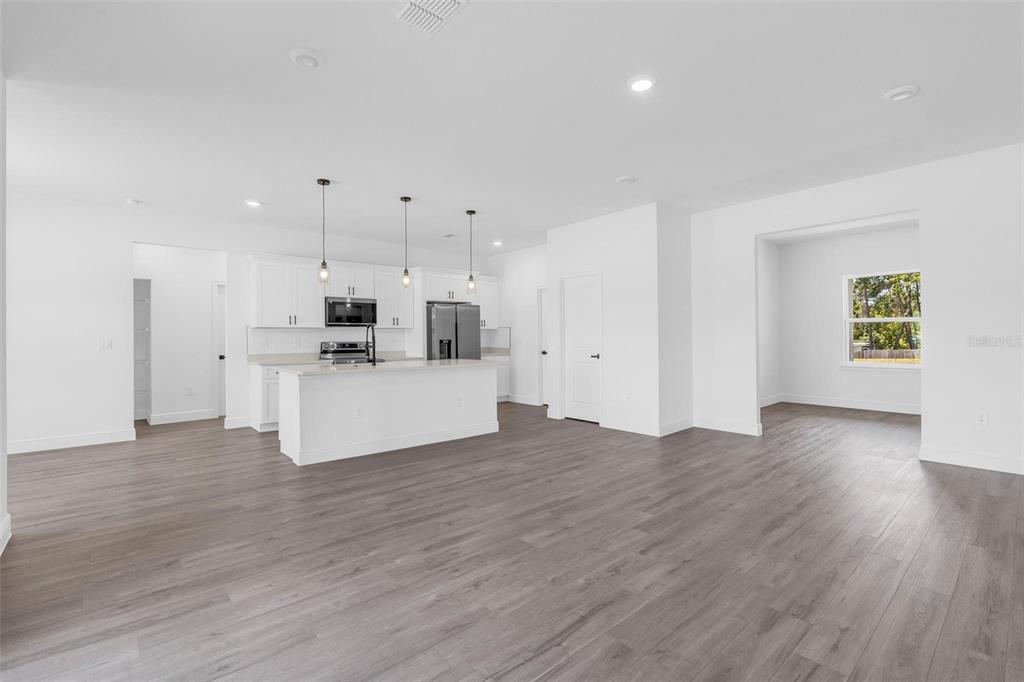 17109 Southwest 41st Circle Ocala, FL 34473 - Photo 11 of 72 a view of a kitchen with an empty room and wooden floor