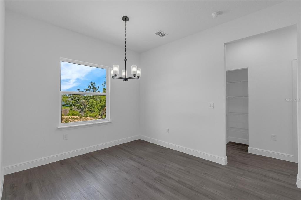 17109 Southwest 41st Circle Ocala, FL 34473 - Photo 26 of 72 a view of empty room with wooden floor chandelier and window