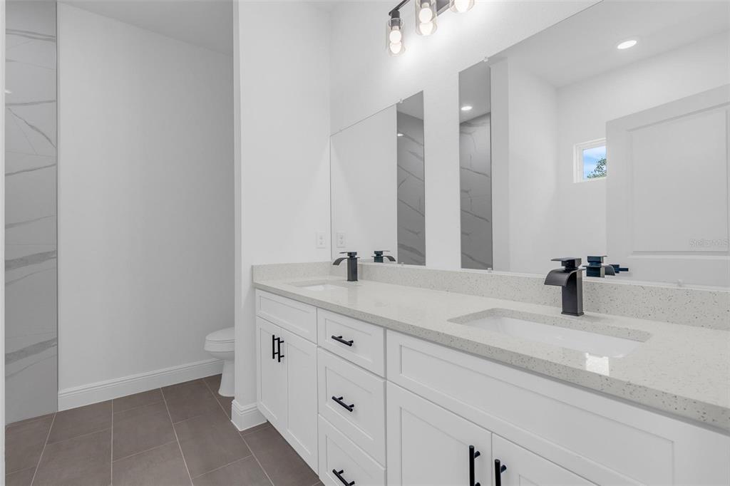 17109 Southwest 41st Circle Ocala, FL 34473 - Photo 33 of 72 a bathroom with a double vanity sink and a mirror