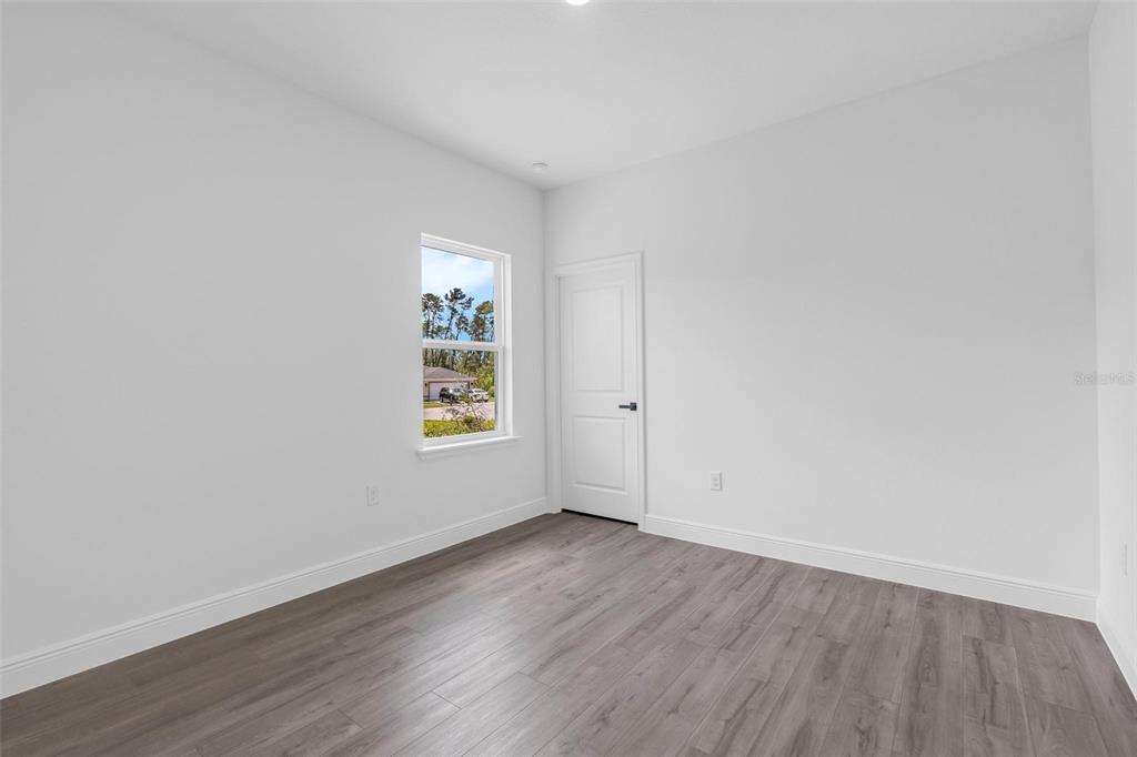17109 Southwest 41st Circle Ocala, FL 34473 - Photo 43 of 72 an empty room with wooden floor and window