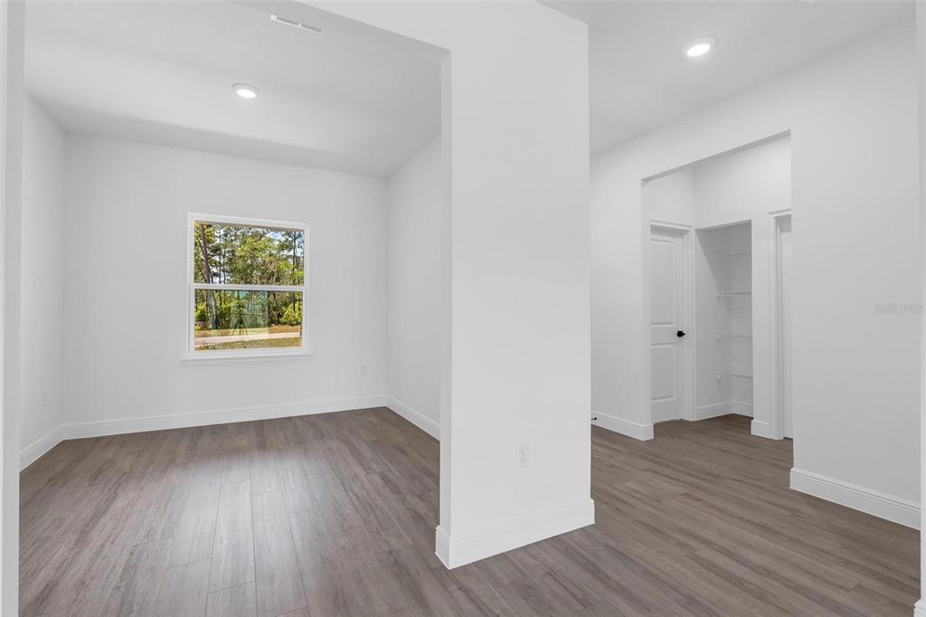 17109 Southwest 41st Circle Ocala, FL 34473 - Photo 8 of 72 an empty room with wooden floor and windows