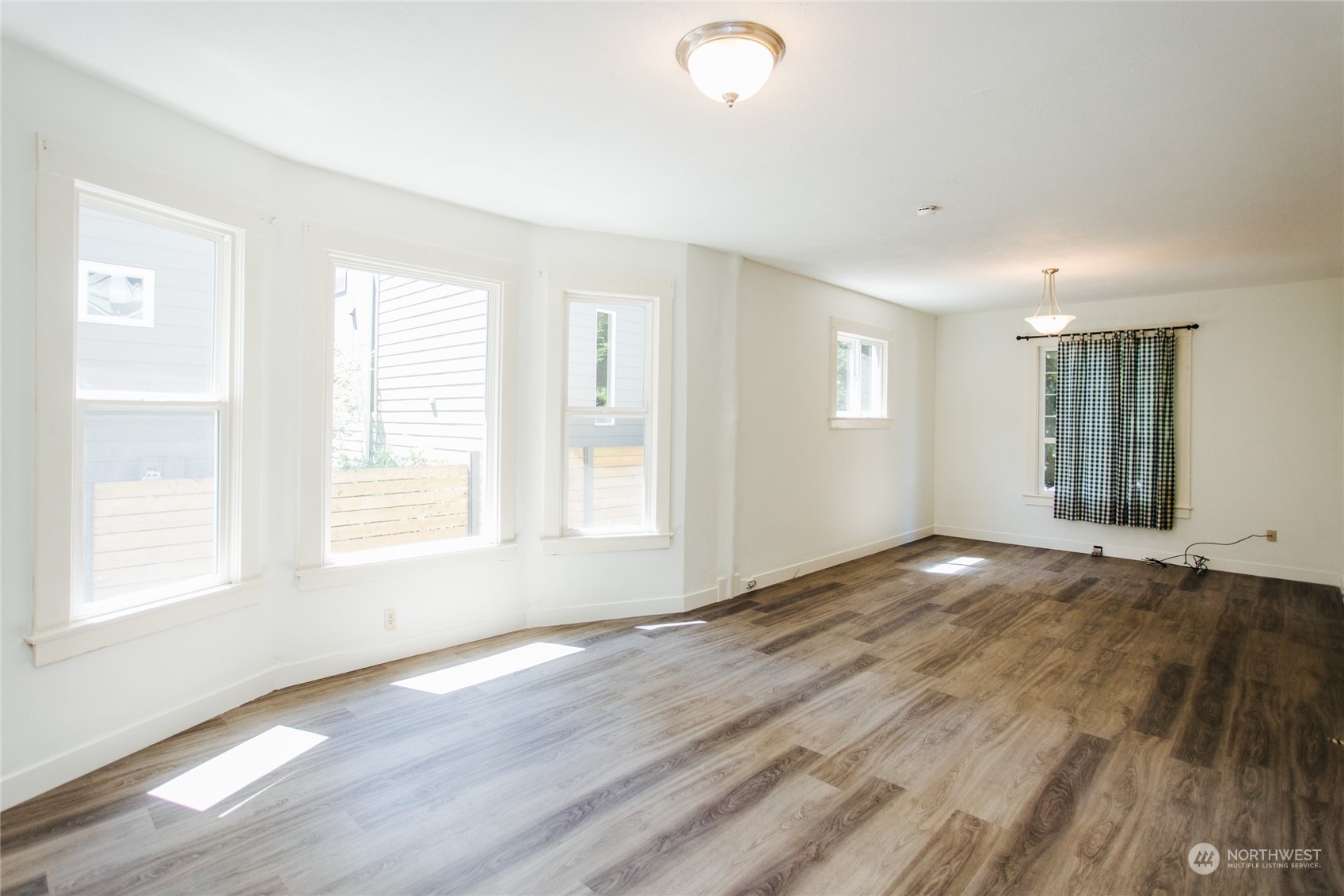 4122 Whitman Avenue North Seattle, WA 98103 - Photo 6 of 28 an empty room with wooden floor and windows