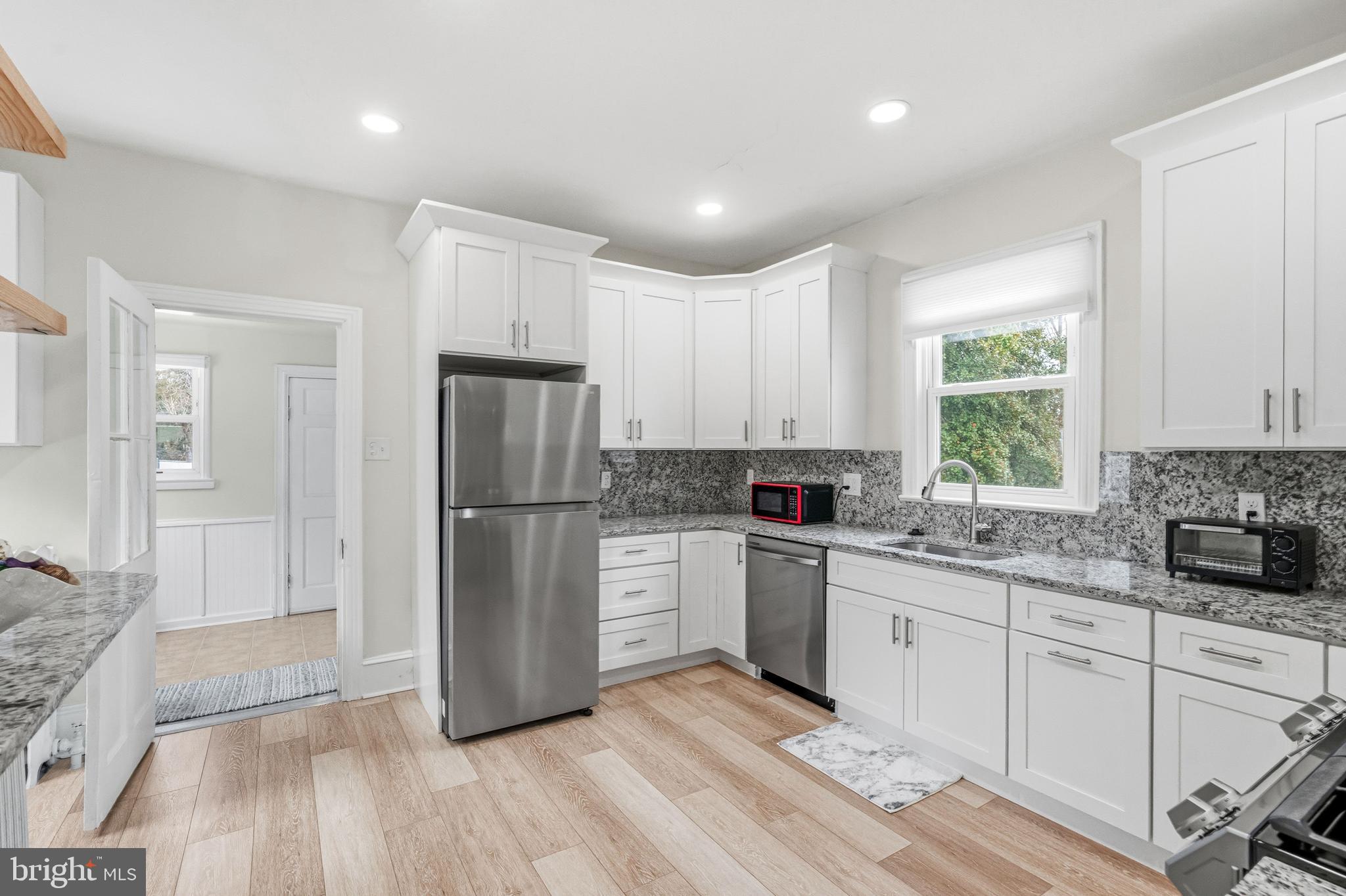 213 South Church Street Moorestown, NJ 08057 - Photo 5 of 54 a kitchen with a refrigerator a sink dishwasher a stove and white cabinets with wooden floor