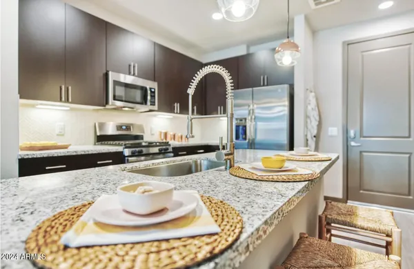 a kitchen with granite countertop stainless steel appliances a sink and a stove