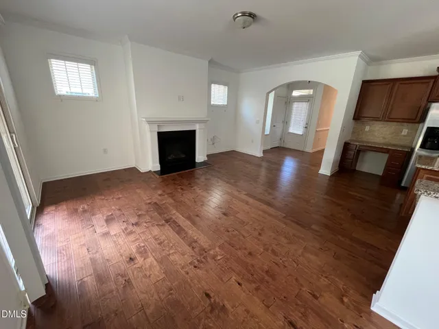 a view of empty room with wooden floor and fireplace