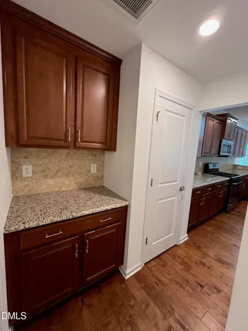 a kitchen with granite countertop cabinets and wooden floor