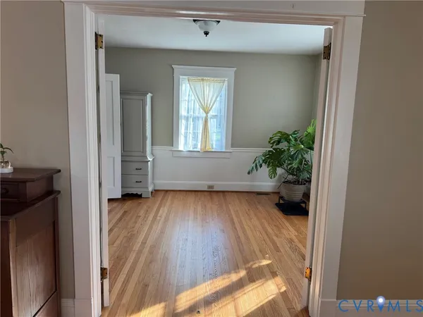 wooden floor in an empty room with a window