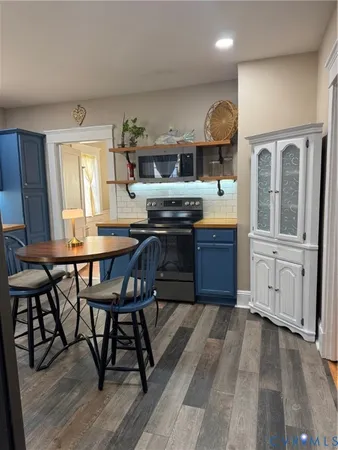 a kitchen with granite countertop a stove a sink and chairs