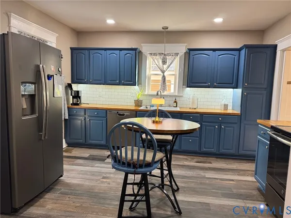 a kitchen with stainless steel appliances granite countertop a sink a stove a refrigerator and wooden cabinets