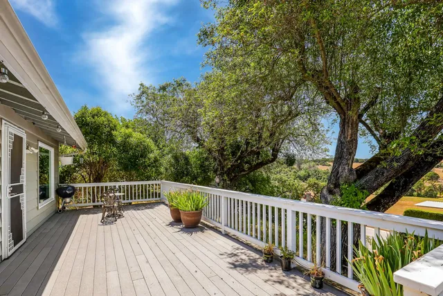 a white house with tall trees in the background