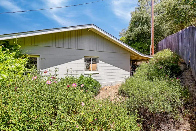 an aerial view of residential house with outdoor space and trees all around