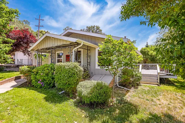 a kitchen with stainless steel appliances granite countertop a dining table chairs cabinets a sink and a window