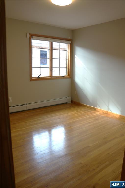520 7th Street, Unit B Palisades Park, NJ 07650 - Photo 11 of 22 a view of an empty room with wooden floor and a window