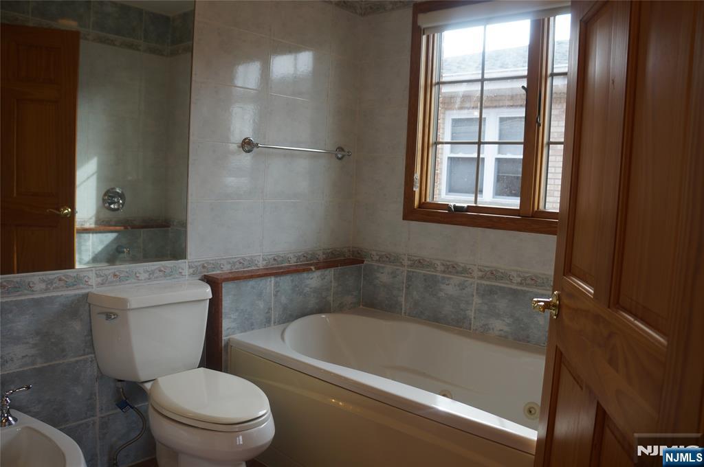 520 7th Street, Unit B Palisades Park, NJ 07650 - Photo 18 of 22 a white bath tub sitting next to a toilet