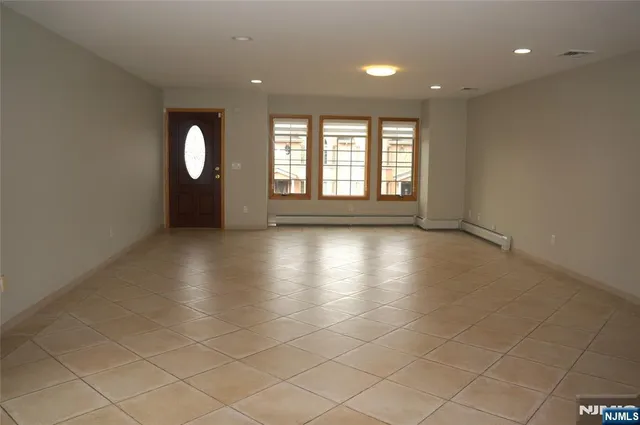 an empty room with windows and glass door