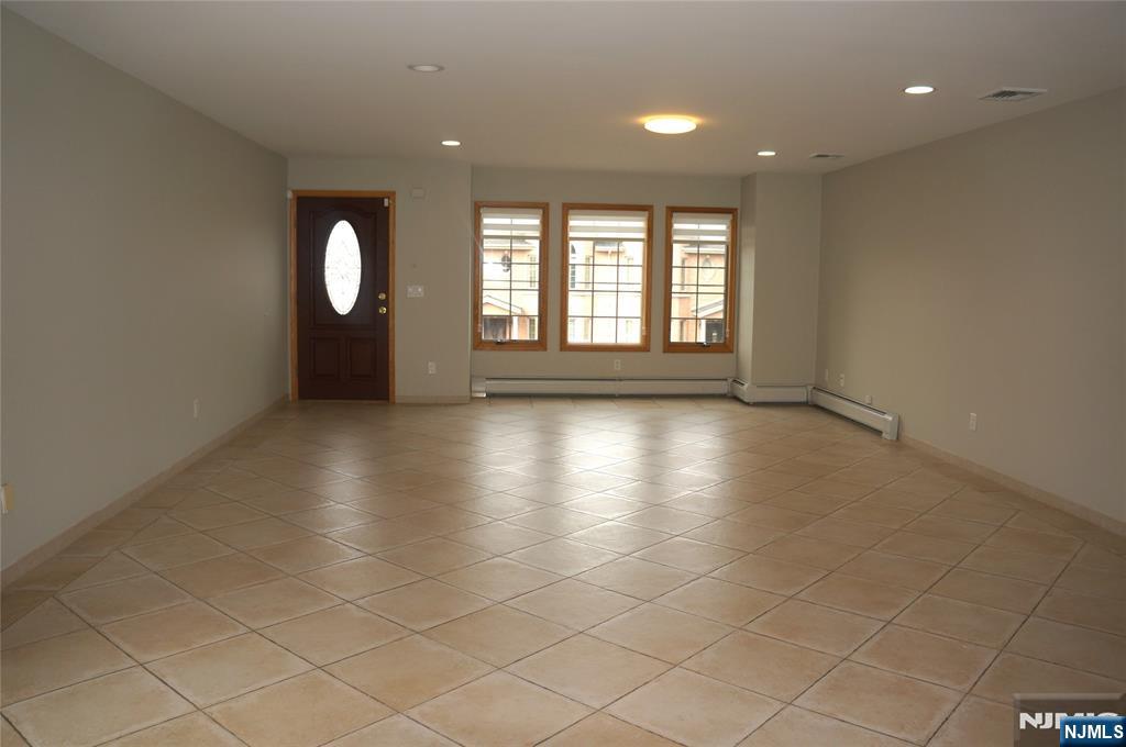 520 7th Street, Unit B Palisades Park, NJ 07650 - Photo 2 of 22 an empty room with windows and glass door