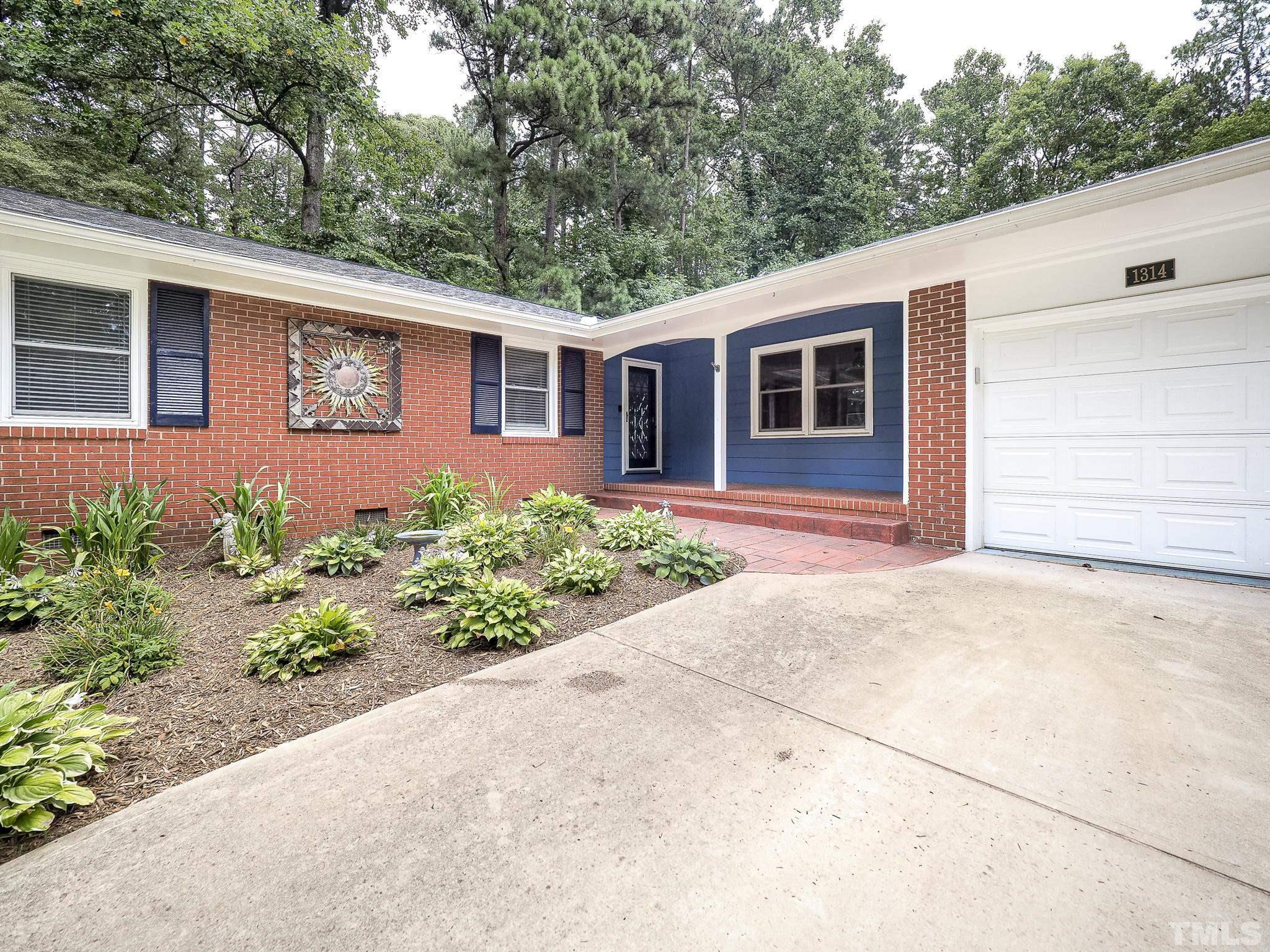 1314 Trinity Circle Raleigh, NC 27607 - Photo 2 of 33 a front view of a house with garden