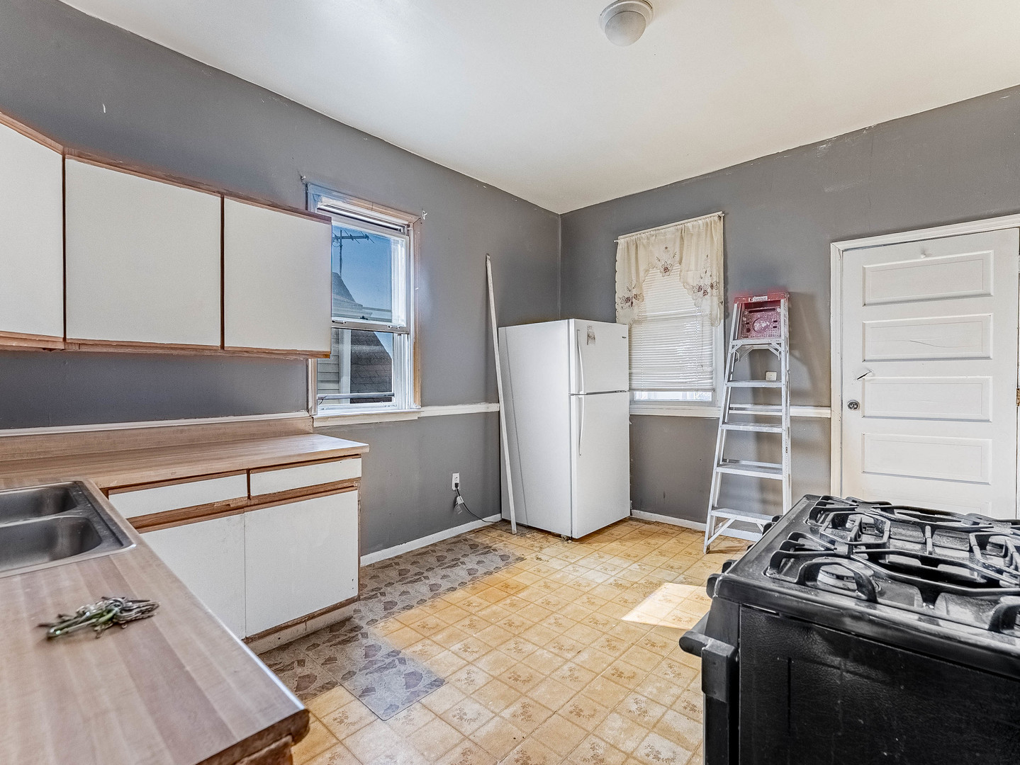 3244 North Drake Avenue Chicago, IL 60618 - Photo 8 of 37 a kitchen with a refrigerator and white cabinets