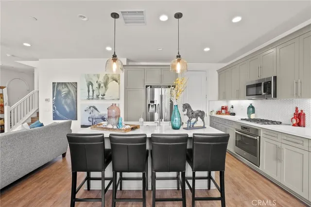 a kitchen with a dining table chairs sink and cabinets