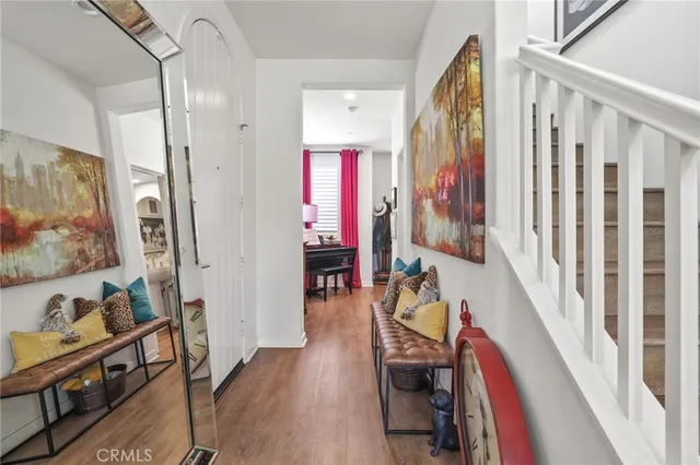 a hallway with wooden floor stairs and furniture