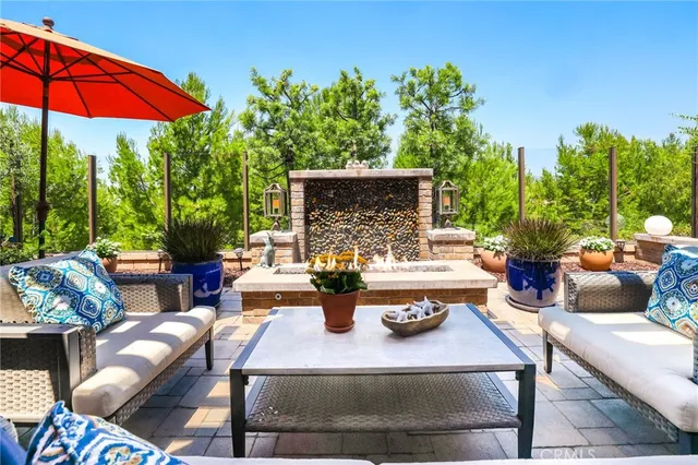 a view of a patio with chairs and table under an umbrella