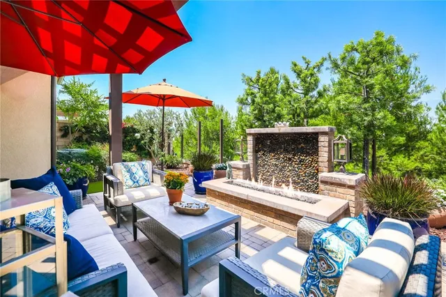 an outdoor sitting area with furniture and umbrella