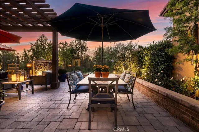 a view of a roof deck with table and chairs under an umbrella
