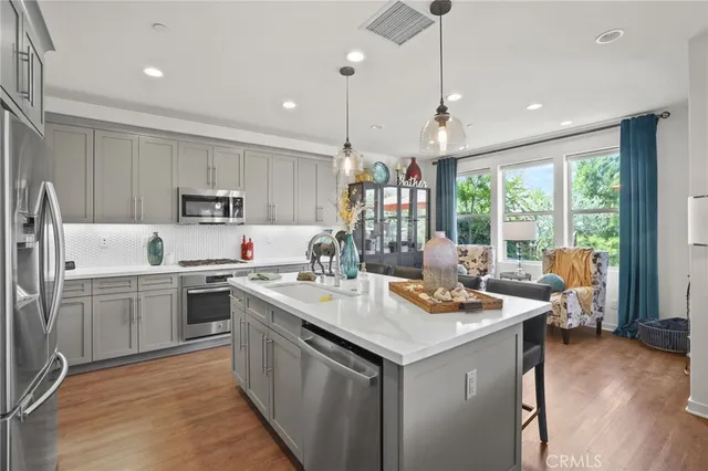 a kitchen filled a sink a counter top space stainless steel appliances and cabinets