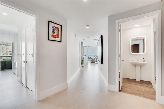 a view of a hallway with wooden floor and a living room