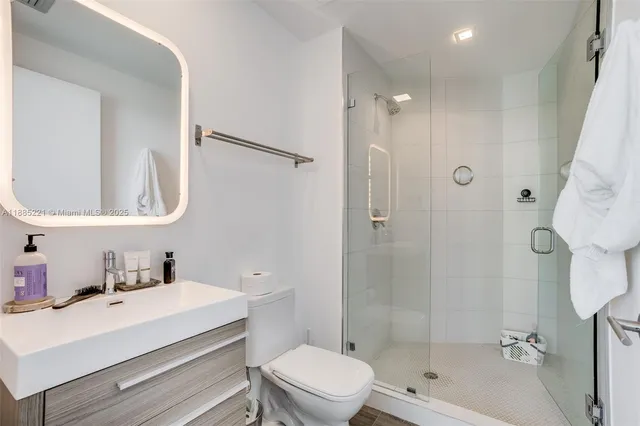 a bathroom with a sink toilet a mirror and shower