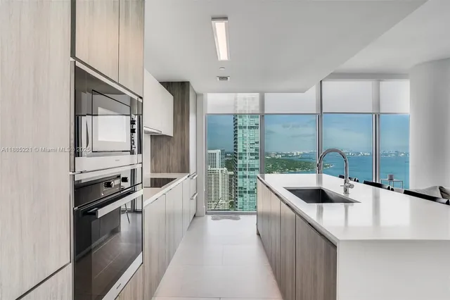 a kitchen with stainless steel appliances granite countertop a sink and a refrigerator