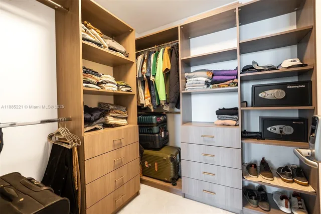 a view of walk in closet with clothes and shoes