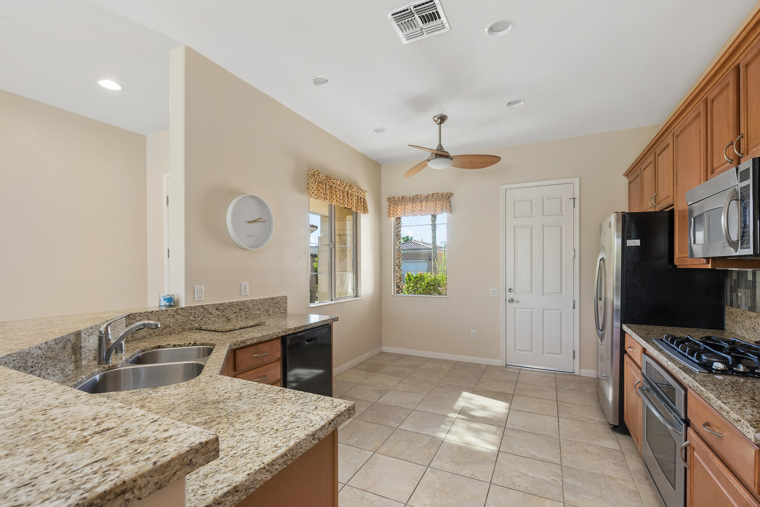 81935 Avenida Bienvenida Indio, CA 92203 - Photo 7 of 35 a kitchen with granite countertop a sink a stove top oven and cabinets