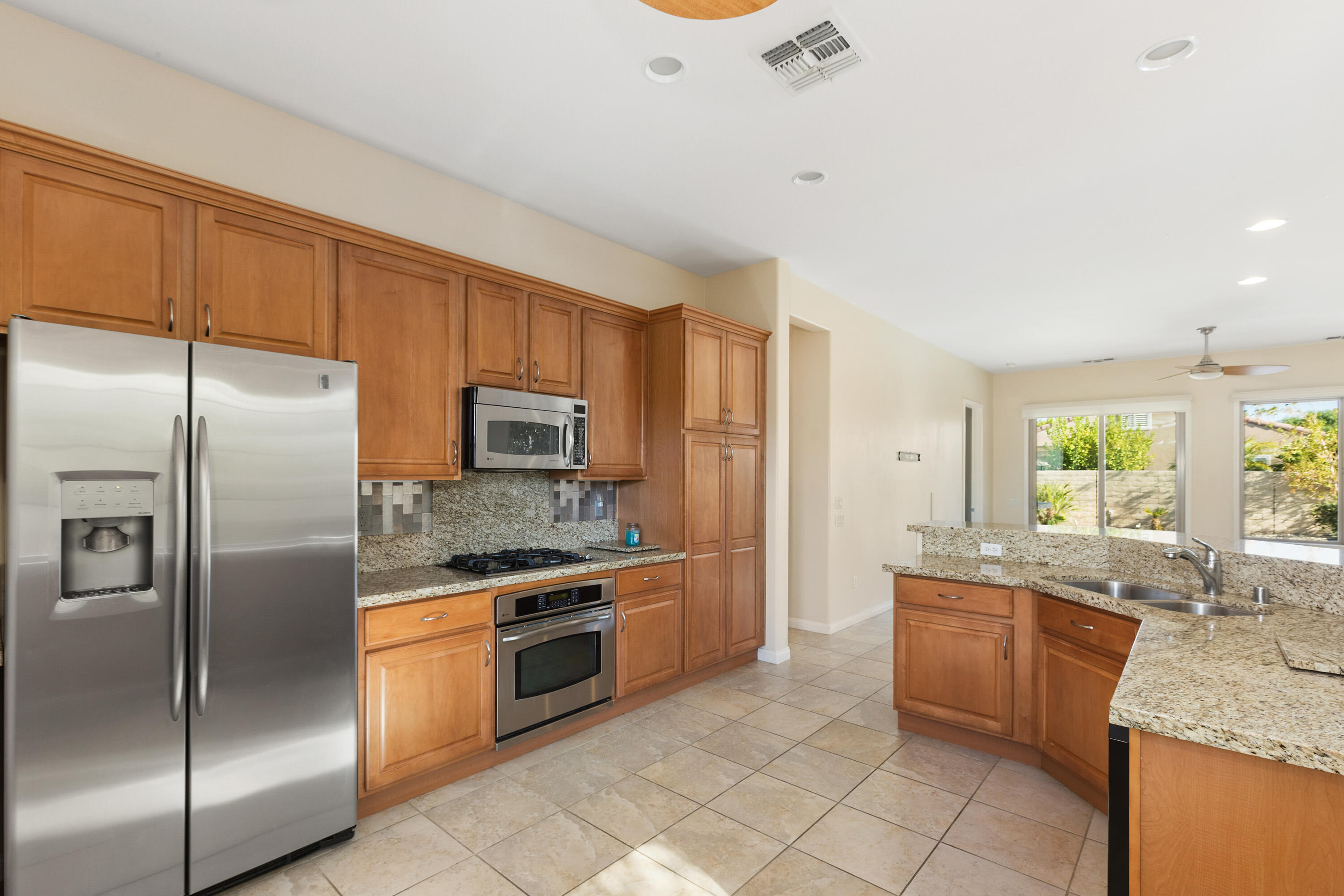 81935 Avenida Bienvenida Indio, CA 92203 - Photo 9 of 35 a kitchen with stainless steel appliances granite countertop a sink stove and refrigerator