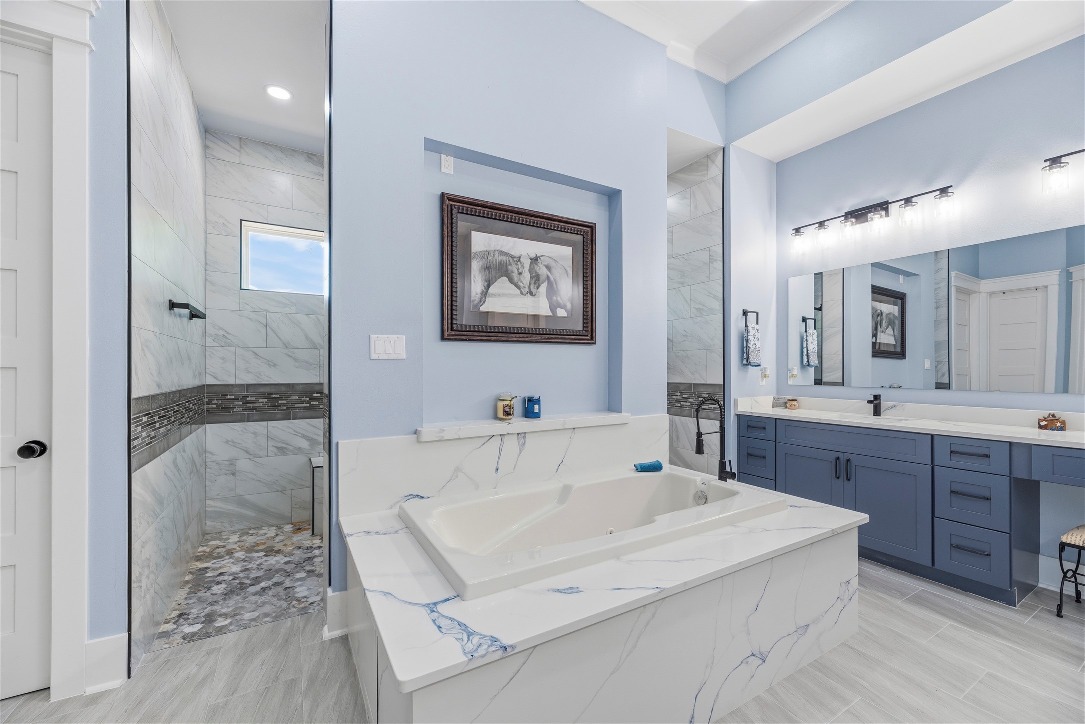 4607 Clayhead Road Richmond, TX 77406 - Photo 17 of 49 Luxurious soaking tub framed by elegant marble-inspired surfaces, creating a tranquil setting for relaxation and rejuvenation.