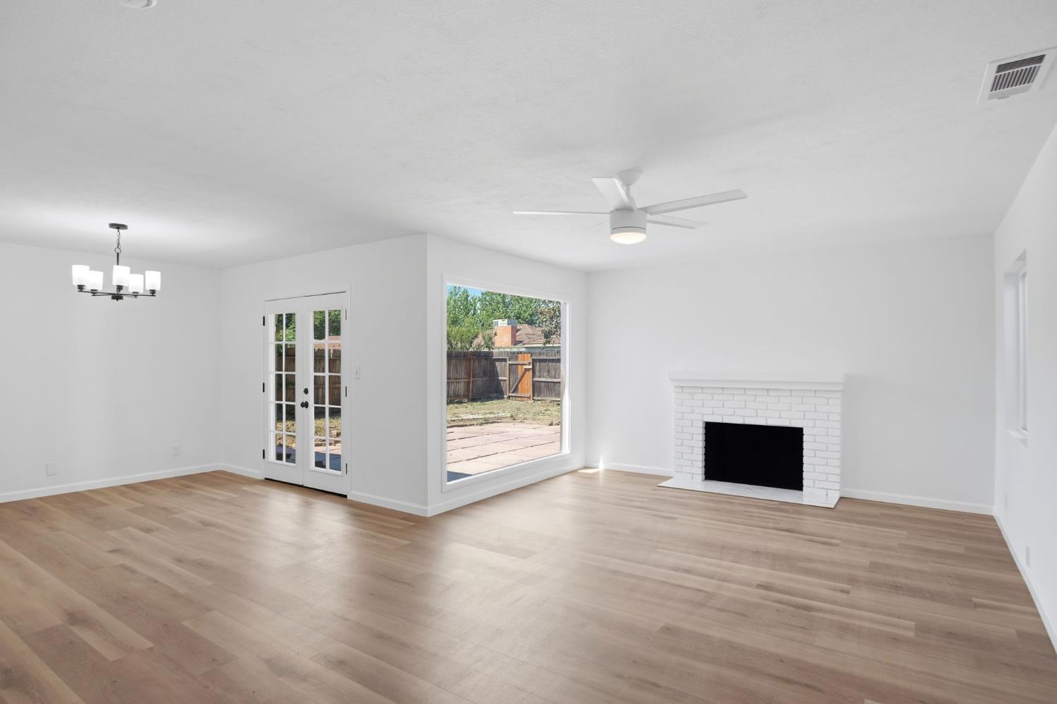 1451 Kent Way Modesto, CA 95355 - Photo 6 of 37 a view of an empty room with wooden floor and a window