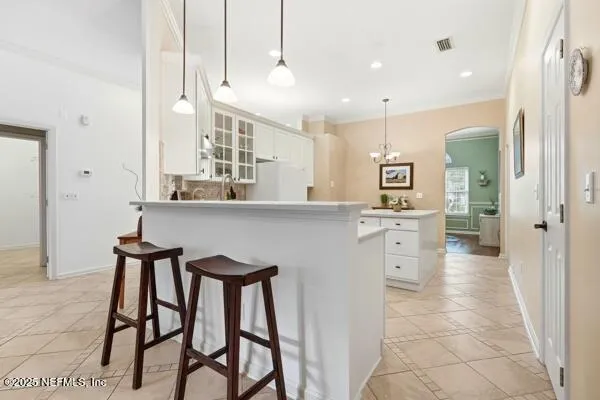 a kitchen with stainless steel appliances kitchen island granite countertop a table chairs sink and cabinets