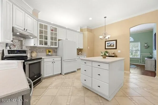 a kitchen with white cabinets and appliances